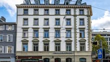 white facade, multiple windows, Starbucks Coffee shop on the ground floor, streetlights and wires above