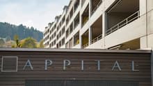 Apartment building with multiple floors, balconies, and a sign reading 'APPITAL'.