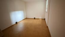 an empty room with wooden floor, white walls, and a window