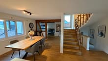 Dining room: Wooden table and chairs, staircase, glass windows, wooden floors
