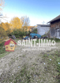 Wooden barn or shed, gravel path, trees with autumn foliage, outdoor equipment or storage