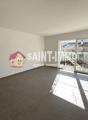 Large open room with gray tile flooring, white walls, and large windows providing natural light. The room features a prominent Saint-Immo real estate agency logo on the wall.