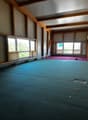 large room, wooden beams, large windows, green carpet, red carpet