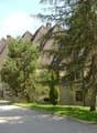 Row of houses with brown roofs, stone walls, windows, and garages