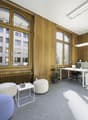 modern office, white desk, office chair, white shelves, plants, carpet floor, large windows, view of city buildings
