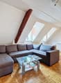 / a large room with a couch, table, and kitchen