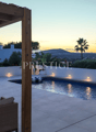 Outdoor area with swimming pool, lounge chairs, umbrella, and a view of the sunset