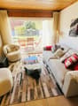 large sofa, coffee table, armchairs, TV, rug, glass door to terrace