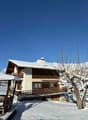 Mountain chalet with terrace, snow-covered, snowy mountains in background