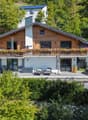 detached house, wooden exterior, balcony with flower boxes, outdoor pool, outdoor seating, garden