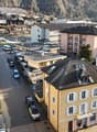 aerial view, neighborhood, residential buildings, cars parked on both sides of the road, multiple stories, some balconies