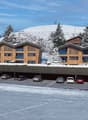 4 story wood structure, covered parking, winter environment, multiple windows, sloping roof