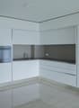 modern kitchen with white cabinets, stainless steel appliances, tiled floor, and a sink with a faucet
