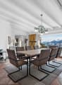 une grande pièce avec une table à manger et des chaises, avec une vue sur les montagnes depuis la cuisine et le salon / a large room with a dining table and chairs, with a view of the mountains from