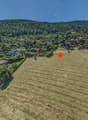 Wide field marked with a red star, surrounded by alpine houses and green trees, distant mountain range