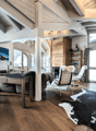 beamed ceiling, wooden floor, fireplace, sofa, coffee table, chess board, two armchairs, carpet, desk, picture on wall