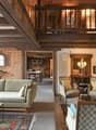 Fireplace, balcony, wooden beams, couch, chairs, table, carpet, wooden flooring