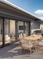 Terrace with table and chairs, potted plant, sliding glass doors, furniture inside visible, couple standing outside