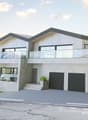 modern 2-story house, concrete exterior, large windows, balcony, staircases, three garages