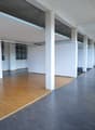 empty office room, wooden floors, gray floors, white walls, pillars, windows