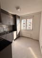 modern kitchen, white tiles, black countertops, stainless steel sink, cabinets, window