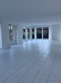 empty room, white walls, glass doors, glass windows, tiled floor, view of outside