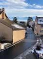 Houses on a street, snow on the ground, mountains in the distance