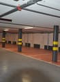large open parking area, white walls, gray floor, columns, numbered parking spaces