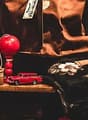 Cluttered room with various items such as a red lamp, toy cars, and framed posters on the walls.
