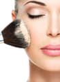 Close-up of a woman applying powder makeup with a brush