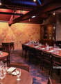 A restaurant with wooden tables and chairs, a long counter, and a hexagonal wall design.