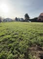 large open grass field, no buildings or objects in sight, a distant house
