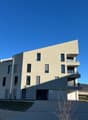 multi-story apartment building, concrete walls, glass windows, balconies