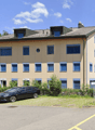 3 story building, beige exterior, blue shutters, car parked in front