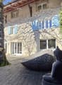 Traditional style building, large windows, wooden deck, Buddha statue, vine-covered facade