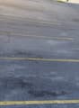 Asphalt parking lot with yellow lines and labeled parking spaces