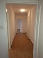 wooden floor, white walls, entrance, doors to rooms, bright lighting