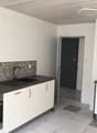 modern kitchen with black countertops, white cabinets, tiled floor, gas stove, modern sink with faucet, white walls, tile backsplash