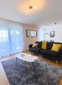 large windows, black sofa, white table, beige carpet, floor lamp, flat screen tv