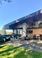 Modern building with outdoor seating area, covered terrace, barbecue, and garden. Located near city.