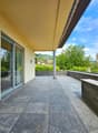 outdoor terrace with sliding glass doors, stone floor, stone railing, overlooking distant landscape
