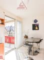white wall, white floor, wooden cabinet, glass door, table and chair, balcony, microwave, potted plant