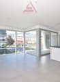 Open kitchen, glass doors leading to terrace, large windows, tiled floor