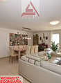 white leather sofa, dining table, glass doors, plants, rug, white walls, ceiling light