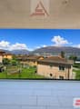 large glass wall, balcony, tiled floor, view of mountains and houses