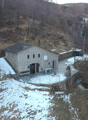 Mountain house, raised ground floor, solar panels on the roof, covered porch, garden, surrounded by trees