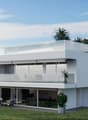 Modern house with two floors, large windows, glass balcony, underground garage, and lush landscaping.