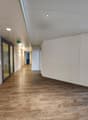 long hallway, white walls, wooden floors, glass doors, lighting fixtures