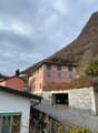 2 story building, multiple windows, garage, hilly surroundings