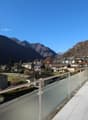modern balcony with panoramic view of valley, glass railings, tiled floor